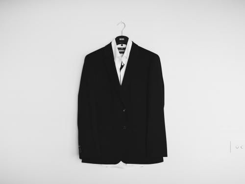 A photo of a black suit jacket hung on a wall.