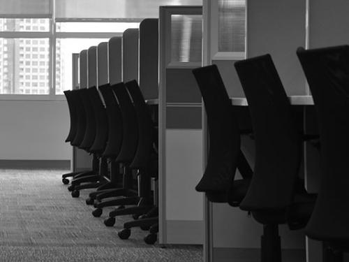 A black and white photo of a row of cubicles.