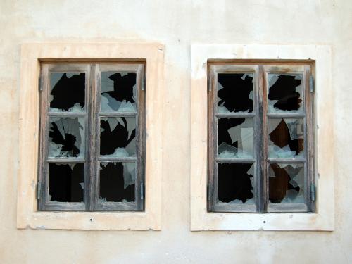 Horizontal photo of two symmetrical pane windows with the glass broken out. 