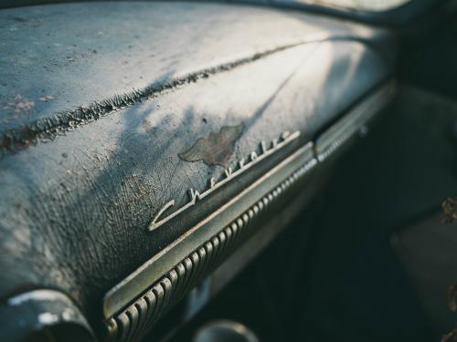 Horizontal photo of a worn dash board of a Chevrolet.