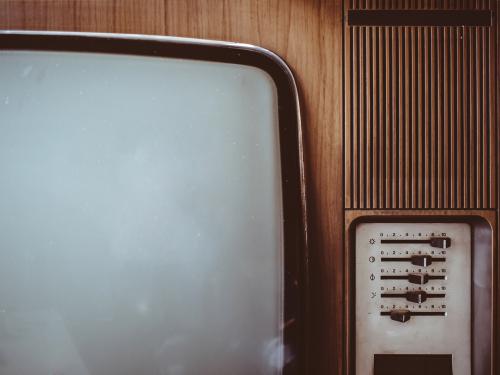 Horizontal photo of a close up of an old brown television. 