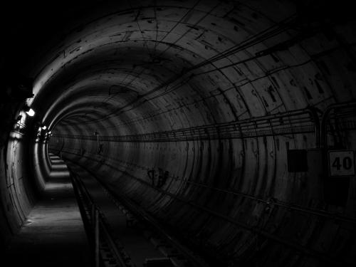 Horizontal photo of a black and white industrial tunnel.