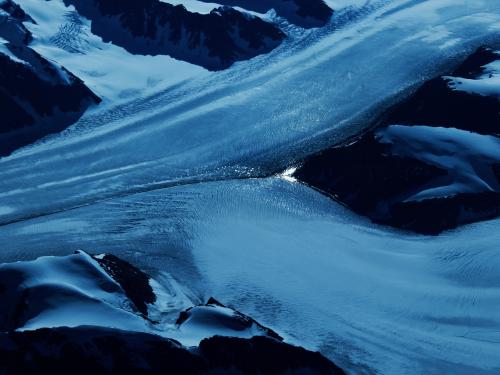 Horizontal photo of two frozen rivers flowing into each other.