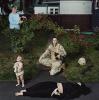 Elizabeth Condon in yard with older woman, baby, and fallen person.