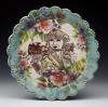 Ornate blue and floral ceramic plate with image of female military person standing proud.